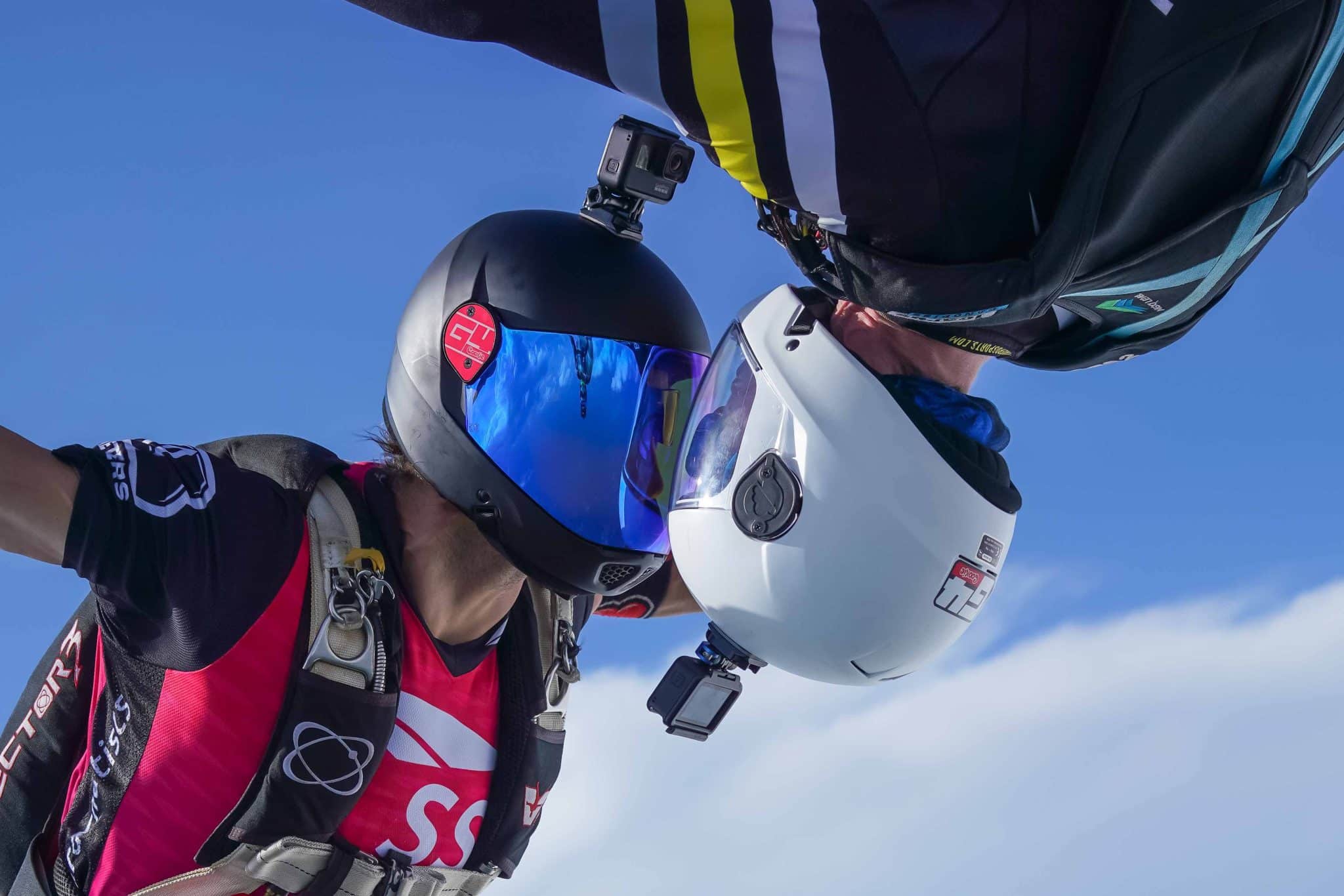 Skydivers in freefall with white and black G4 Cookie helmets