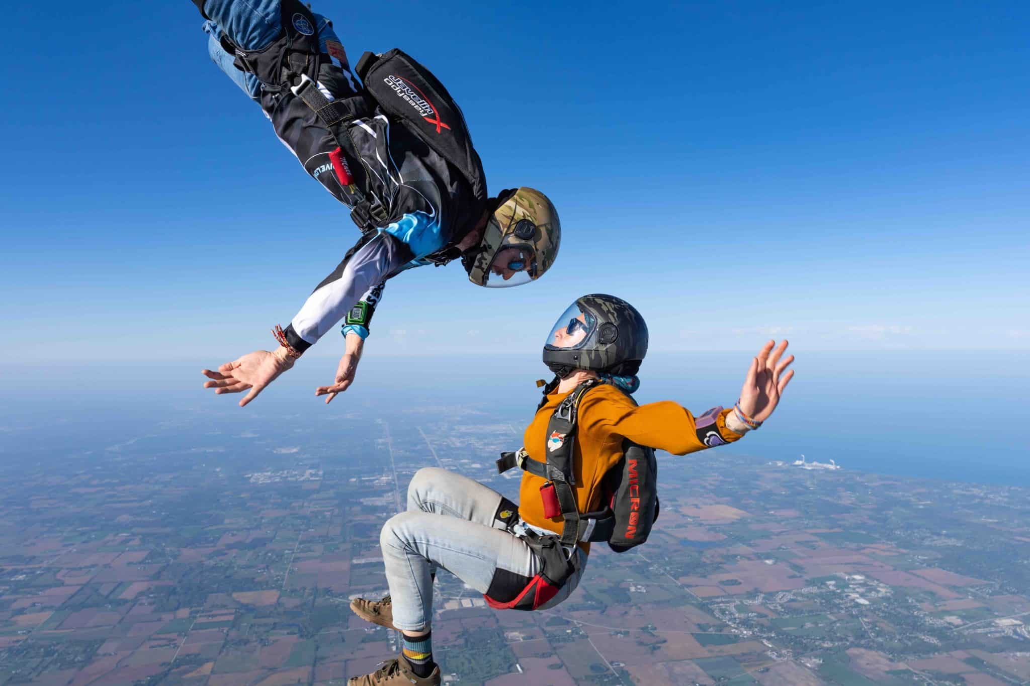 Two skydivers wearing closed face Cookie helmets freeflying