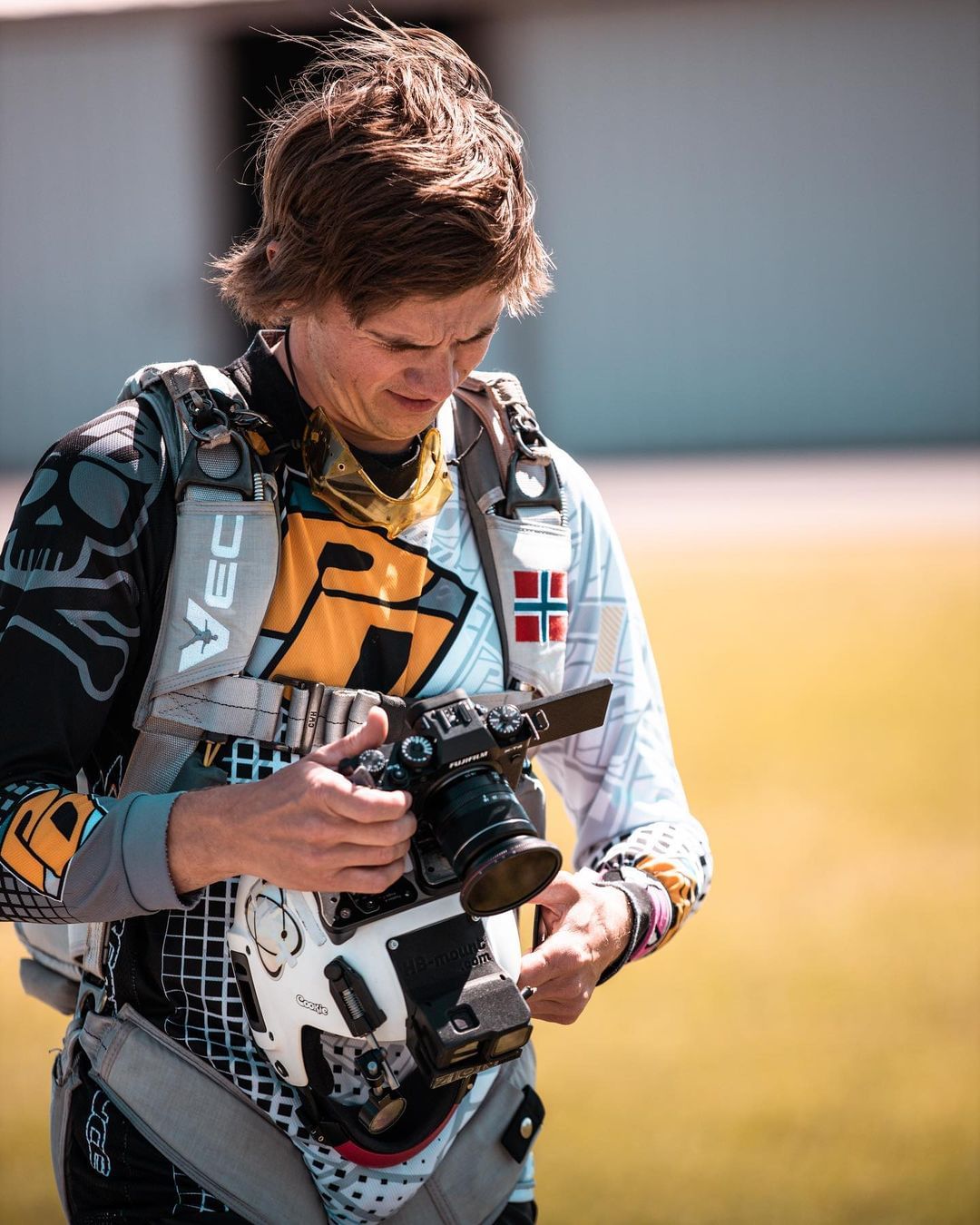 Skydiver looking at his camera while mounted on a white Cookie Fuel helmet