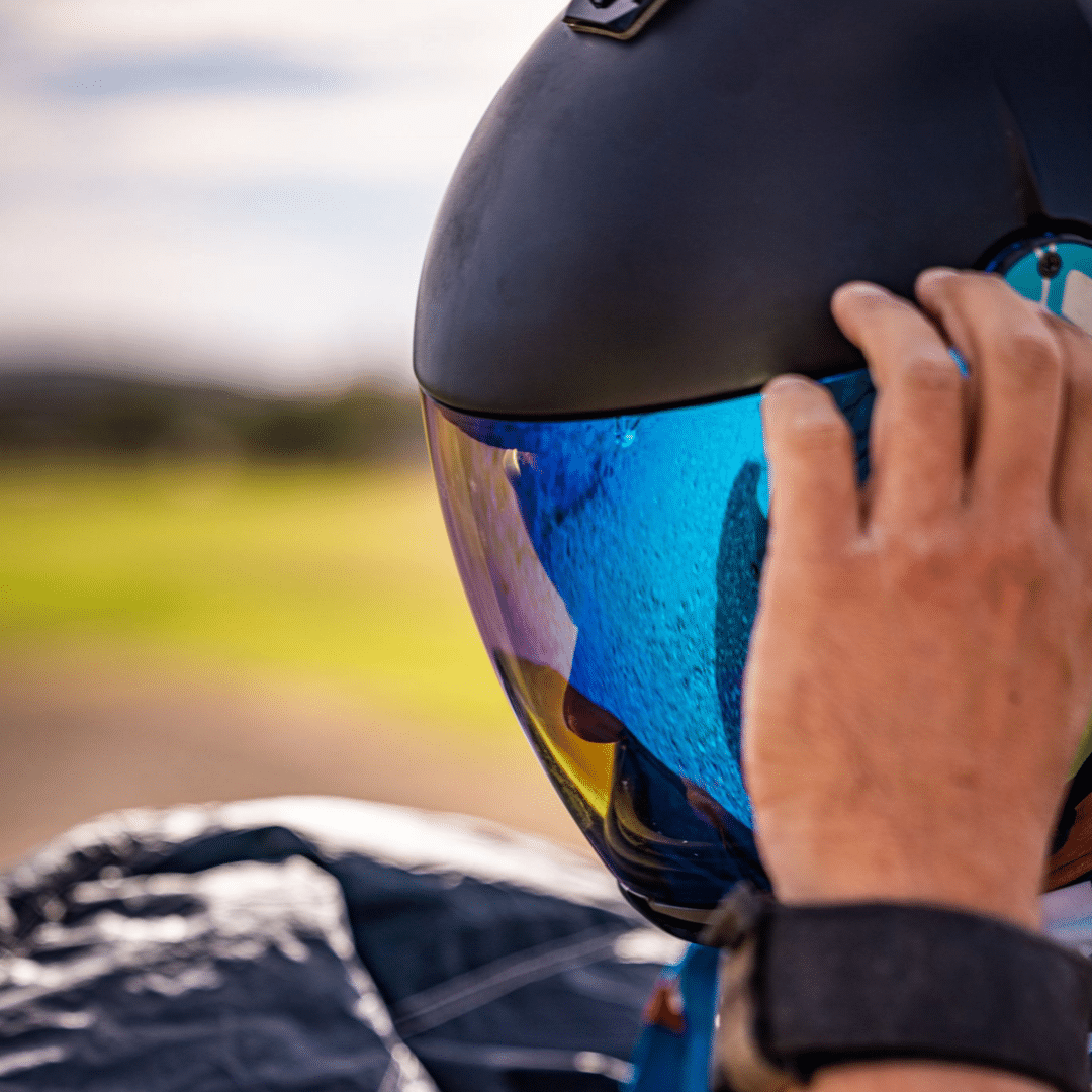 Skydiver wearing a black helmet with reflective visor