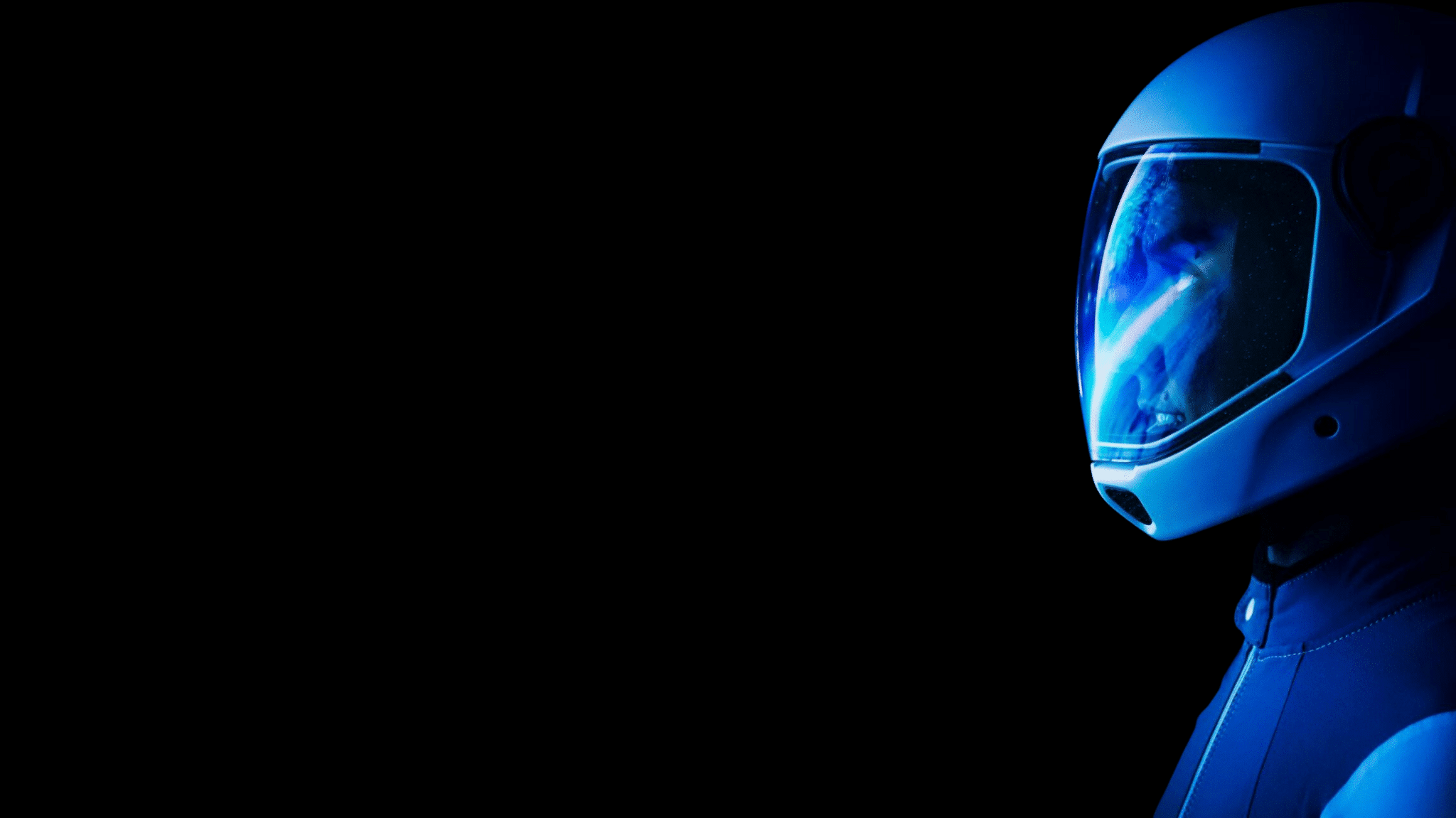 Skydiver wearing a closed face Cookie helmet with blue light and a dark background